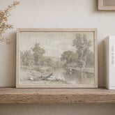 Framed landscape print on a wooden shelf with a book next to it.