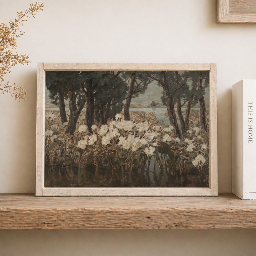 Framed artwork of a landscape with trees and flowers on a wooden shelf.