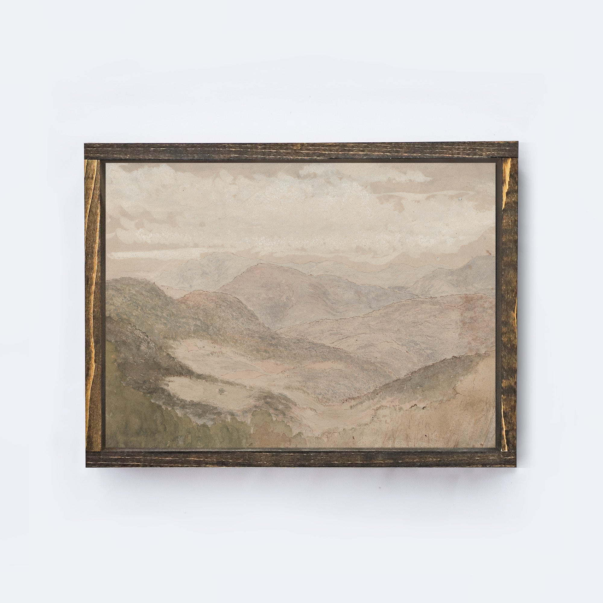 Framed soft mountain landscape painting on a white wall framed in an espresso coloured wood frame.