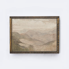 Framed soft mountain landscape painting on a white wall framed in an espresso coloured wood frame.