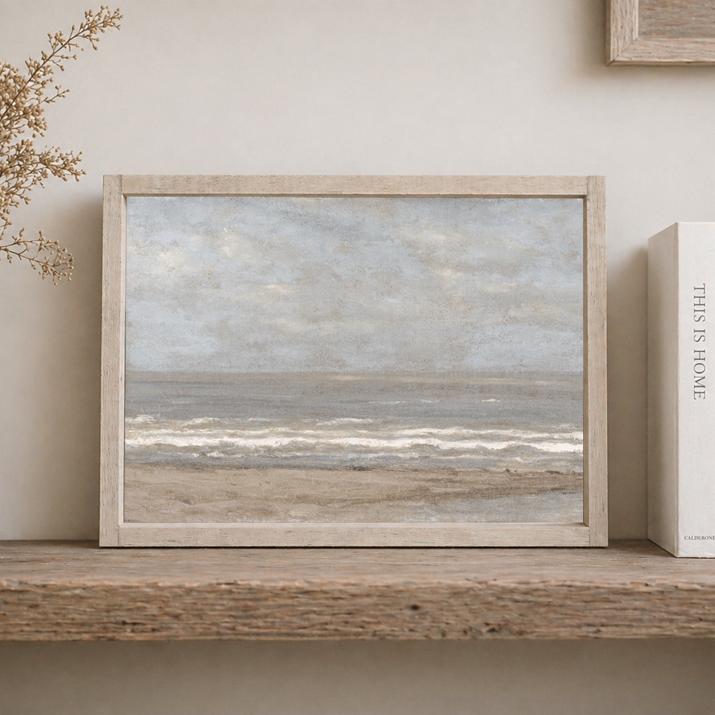 vintage ocean painting with light wood frame on shelf