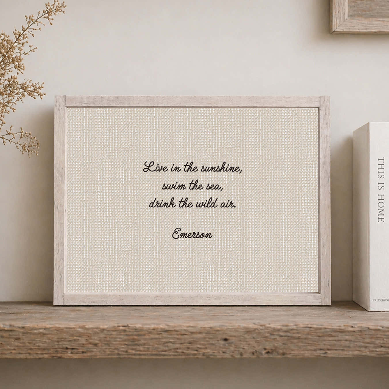 Rustic white framed wood sign with the quote, "Live In The Sunshine, swim the sea, drink the wild air, emerson 